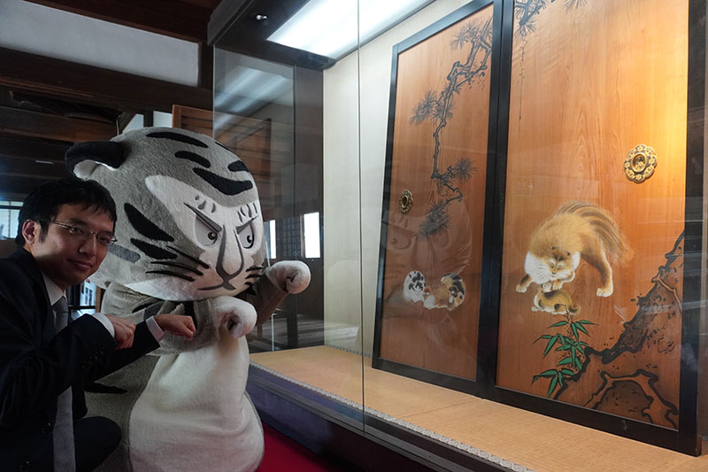 「三方正面真向の猫」のレプリカを眺める2人