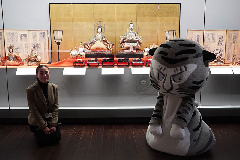 展示ケースの前でお座りする2人