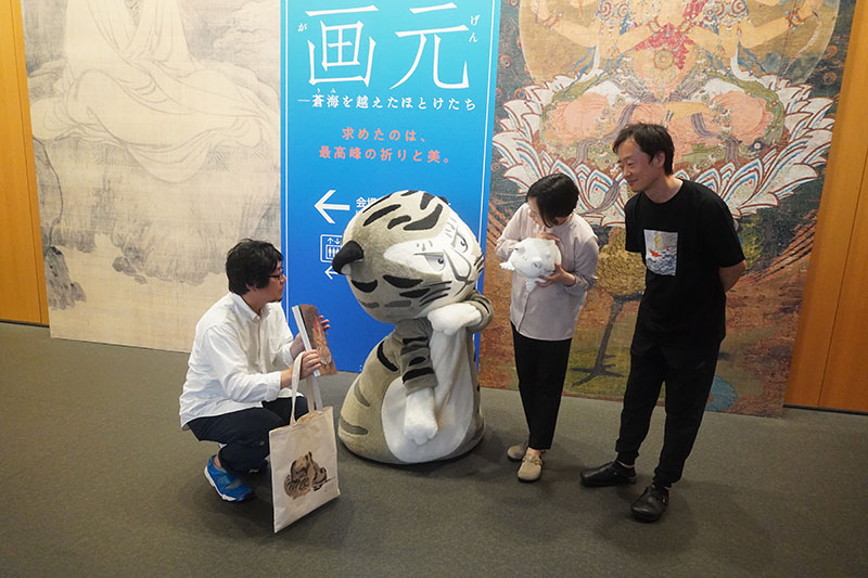 1F看板前でトラりんを囲む三研究員