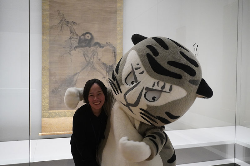 「観音猿鶴図」右幅の前で肩を組む二人