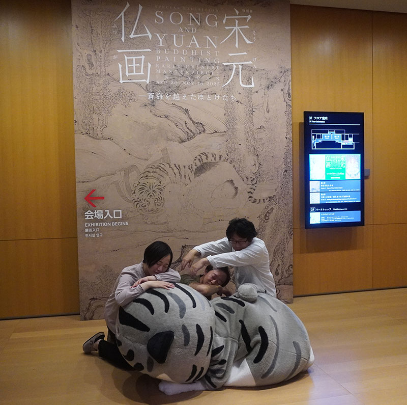 「四睡図」看板の前で眠る4人