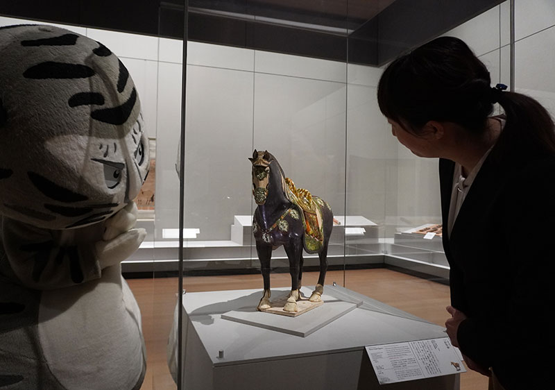 「三彩馬俑」1組のうち黒い馬を眺める二人