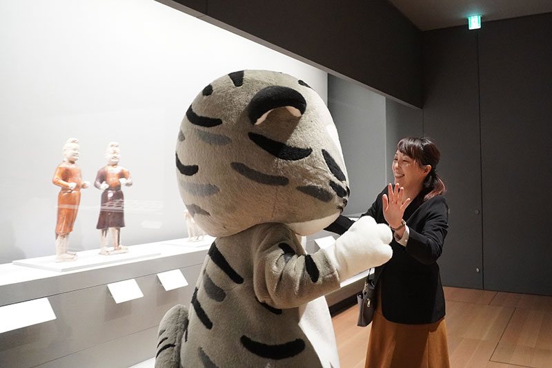 展示ケースの前で手を取り合う二人