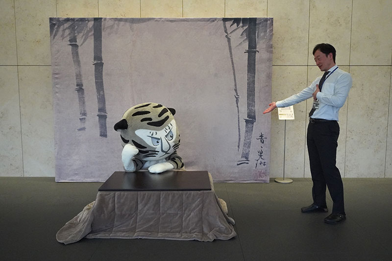 こたつのトラりんのそばに福士研究員登場