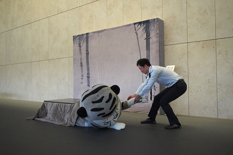 福士研究員に腕を引っ張られ、こたつから引きずり出されるトラりん