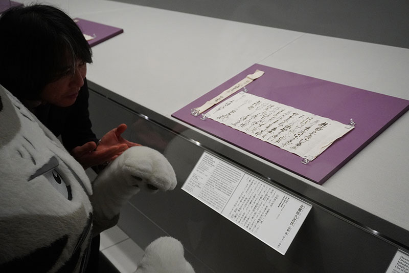 「北郷時久書状（切紙、潤三月十一日付）」を見つめる二人