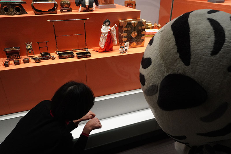 段飾り雛の最下段に展示された生きものを見る二人