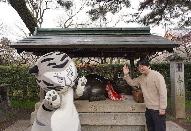 境内、牛の像の前の二人