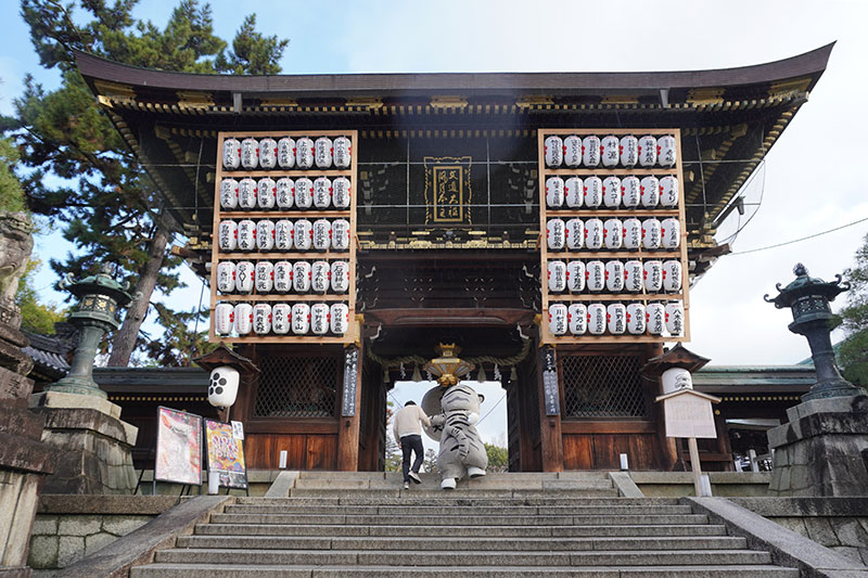 手をつないで楼門前の階段をのぼる二人