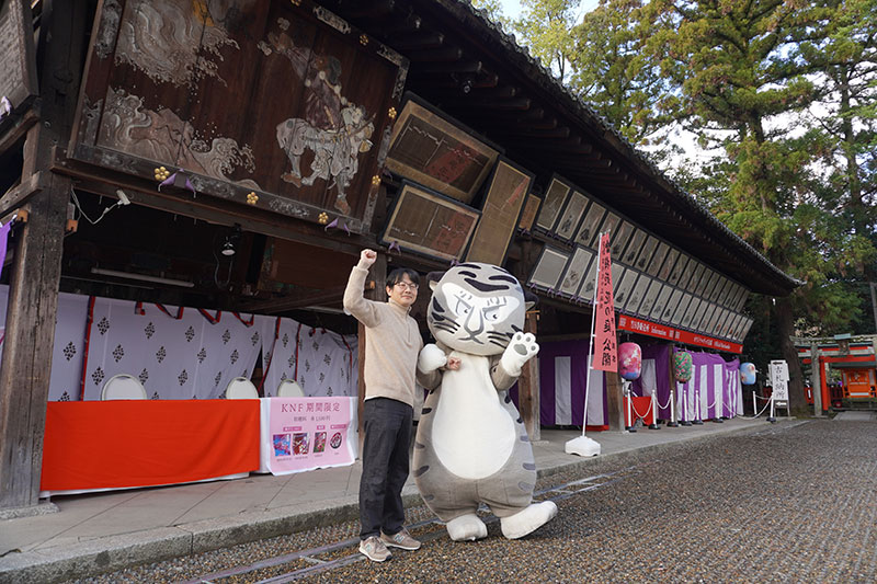 絵馬所の大きな絵馬の前の二人