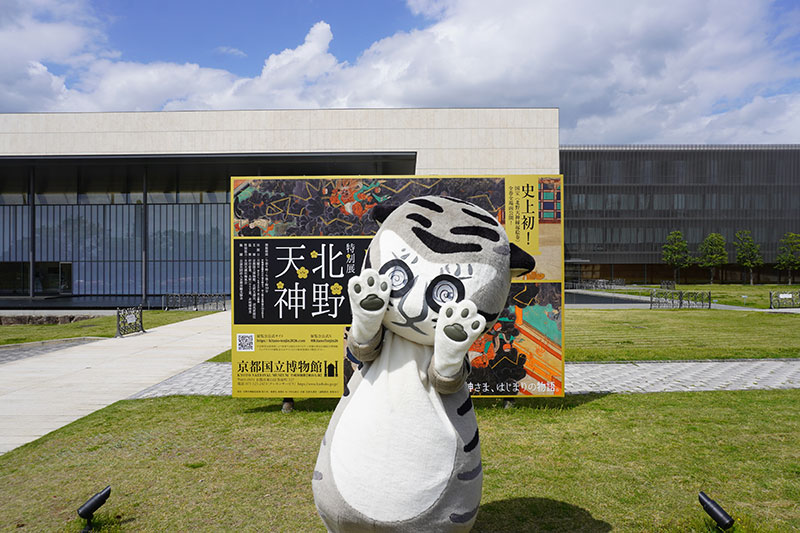 眼鏡をしたトラりん、芝生の上の看板前に登場