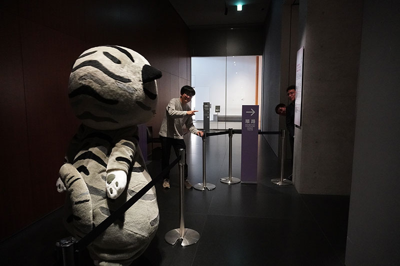 1F奥の展示室にいざなう末兼研究員