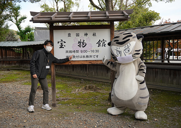 宝物館看板の前の二人