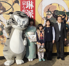 30万人目の来館者　孝橋郁子さんとご家族、当館公式キャラクター トラりん、当館佐々木館長